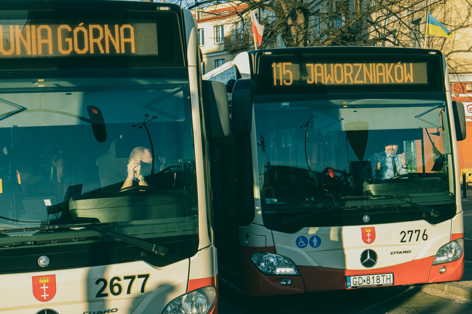 Ilustracja przedstawiająca nowoczesne elektrobusy na tle Ełku, symbolizująca rozwój transportu publicznego i nowe oferty pracy.